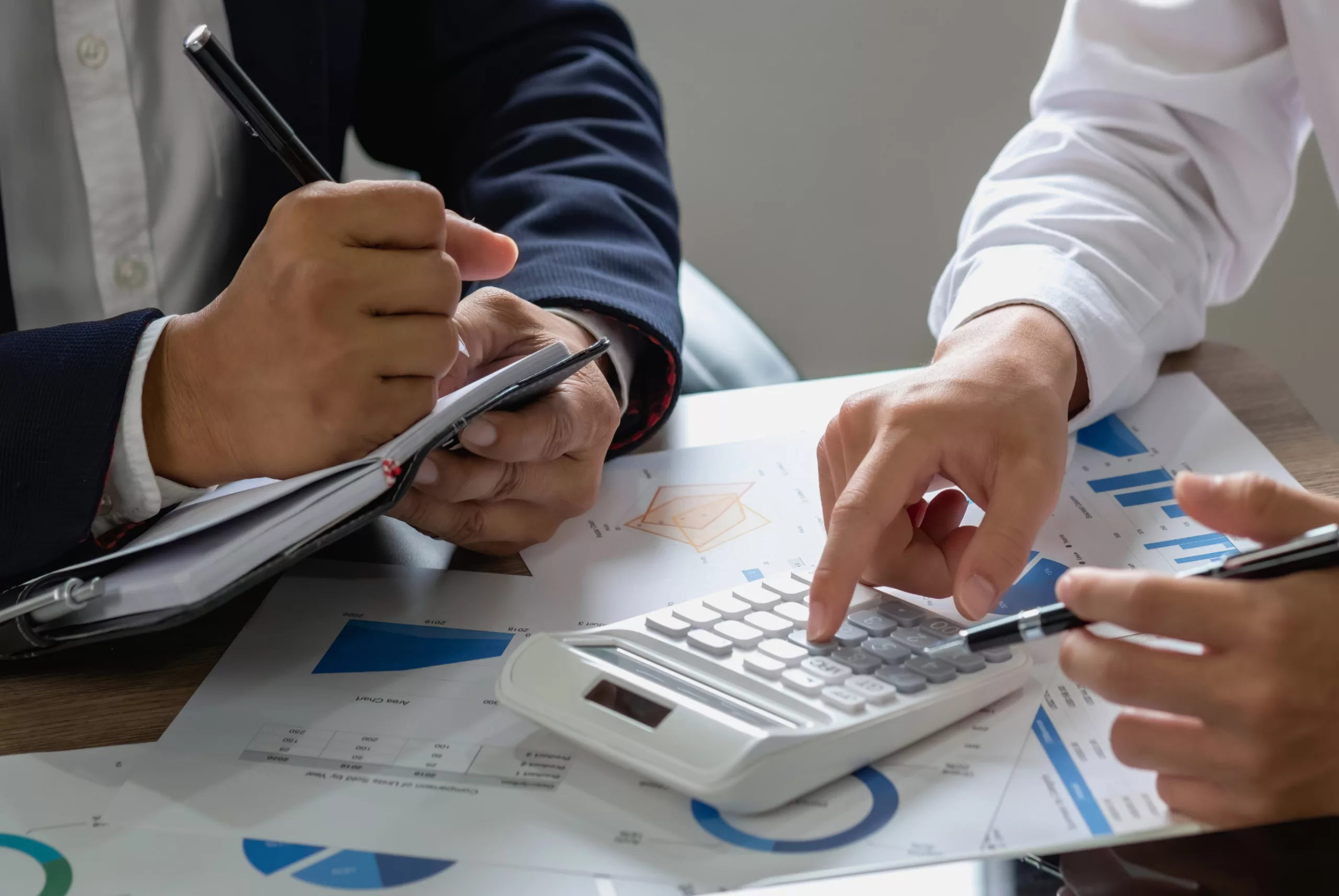 image of two employees working with a calculator and notepad